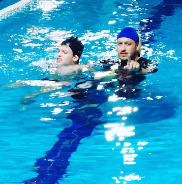 Θεραπευτής καθοδηγεί έφηβο στη θεραπευτική κολύμβηση