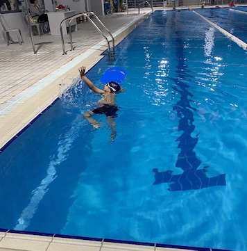 Παιδί εξασκείται ανεξάρτητα με σανίδα στην πισίνα